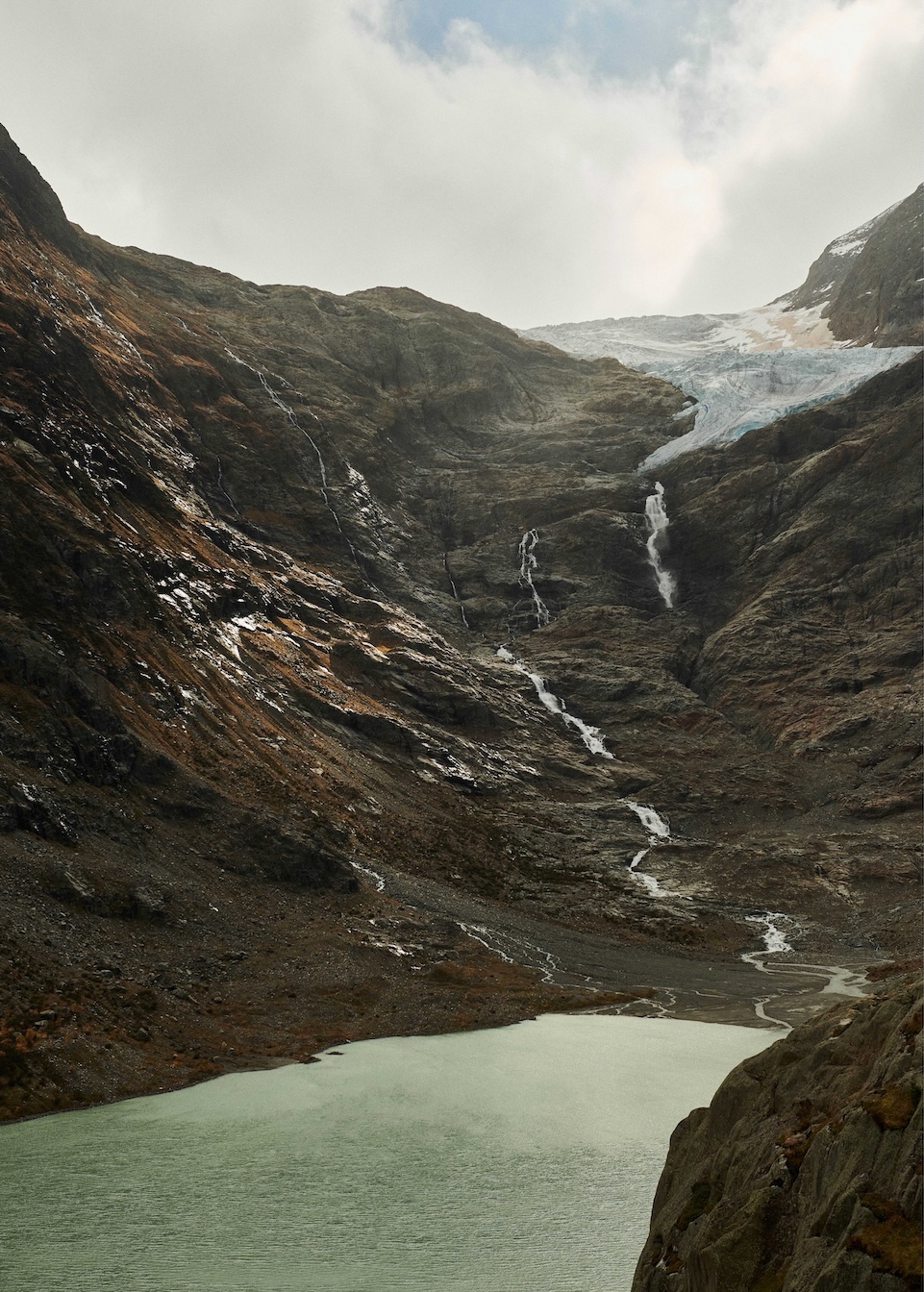 Rückgezogener Gletscher, von dem aus Wasser in einen See fliesst.