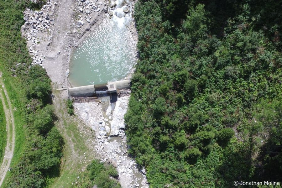 Ein Fluss fliesst zu einem Kraftwerk, darunter fliesst kaum Wasser weiter.